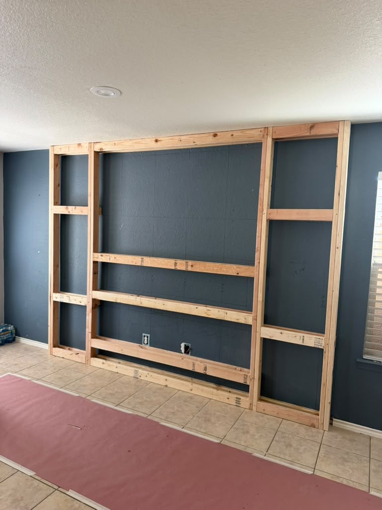Floor-to-ceiling wood framing for a custom living-room feature wall