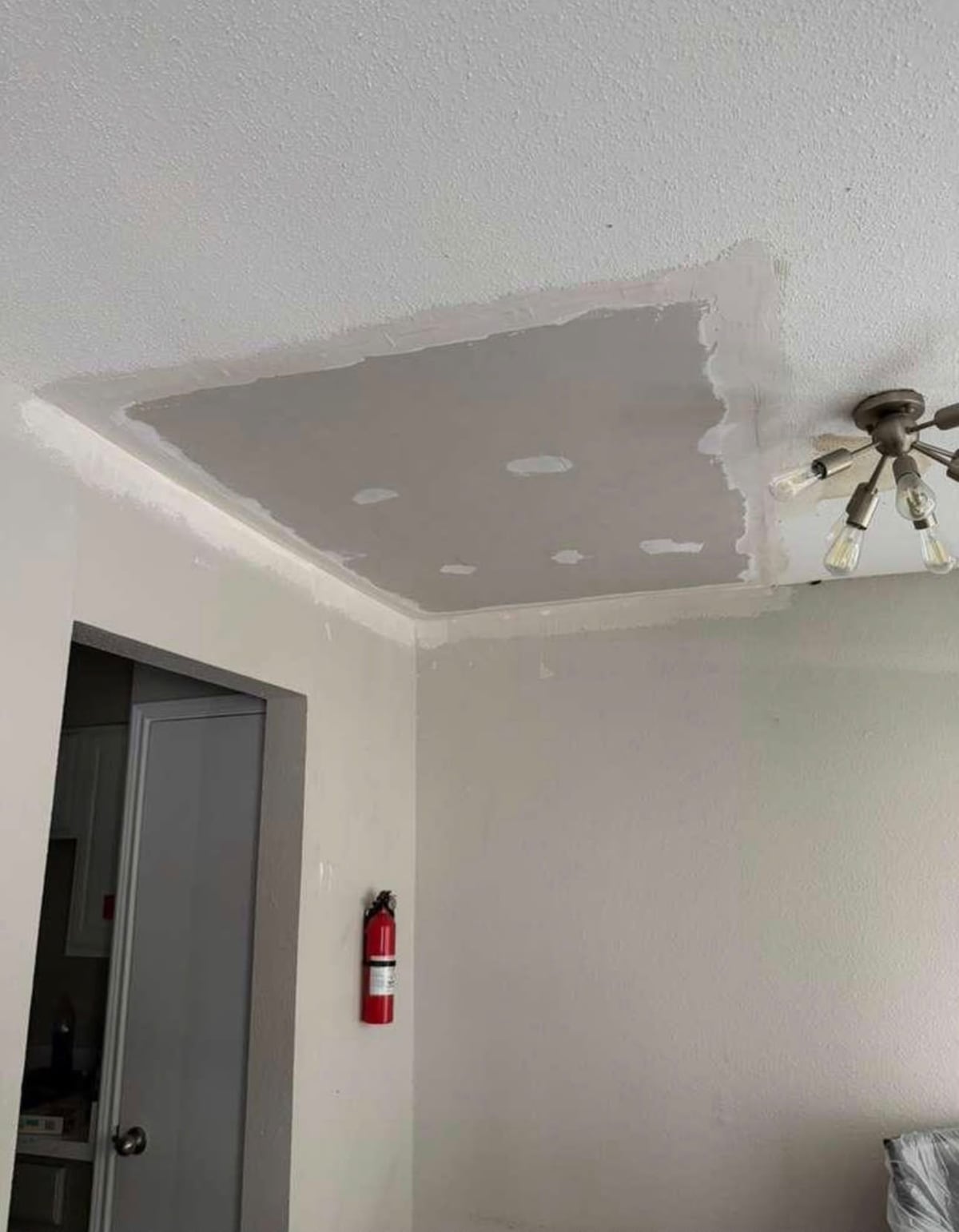 Large ceiling drywall patch taped and coated during repair