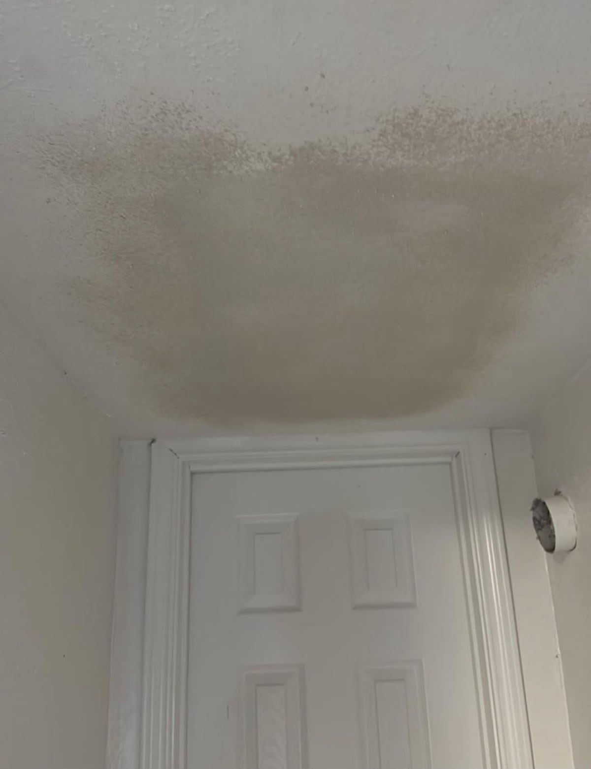 Ceiling texture blended above an interior doorway after repair