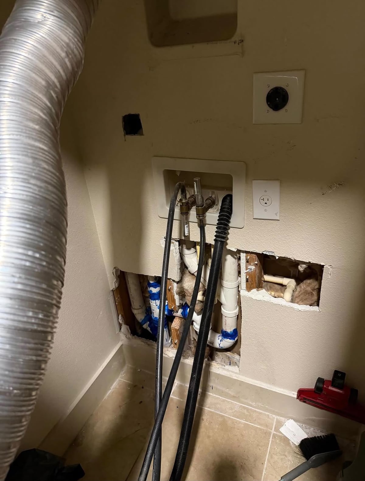 Utility room drywall opened around washer drain and supply connections