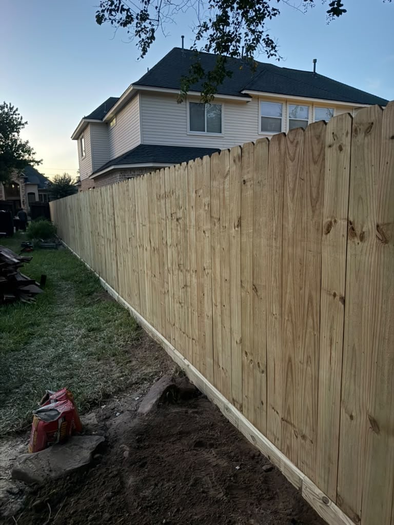 Completed wood privacy fence with closely spaced vertical pickets